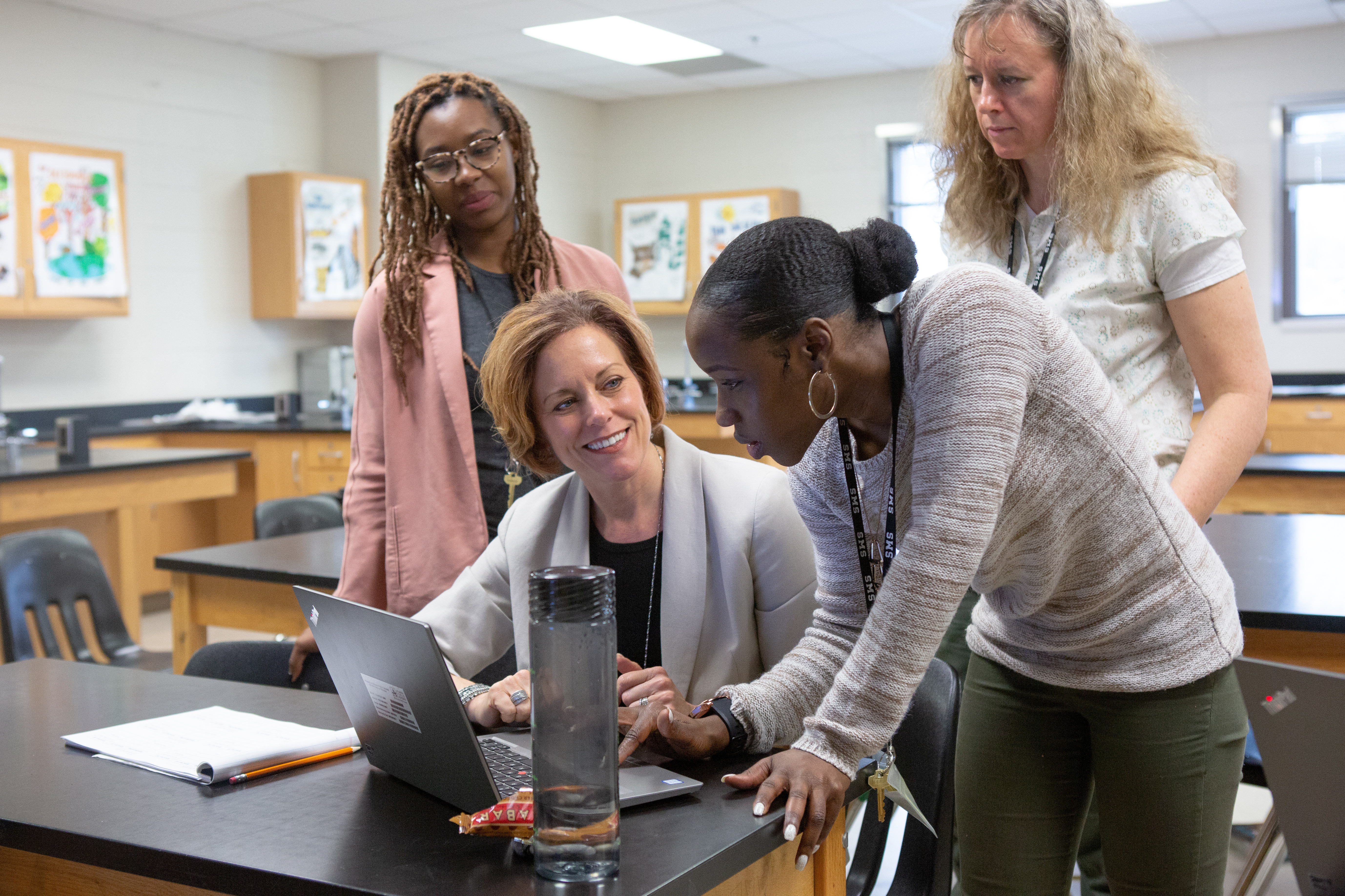 Teachers working together around a computer.